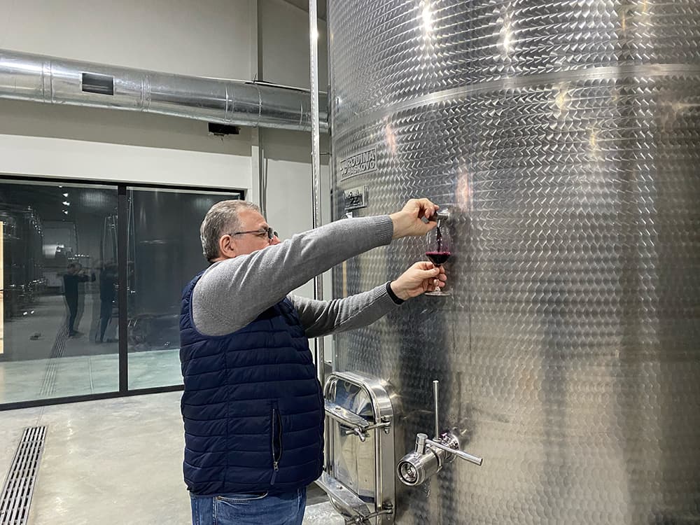MUKADO WINESの醸造所でステンレスタンクからワインを試飲するラド・ウズナシュヴィリ